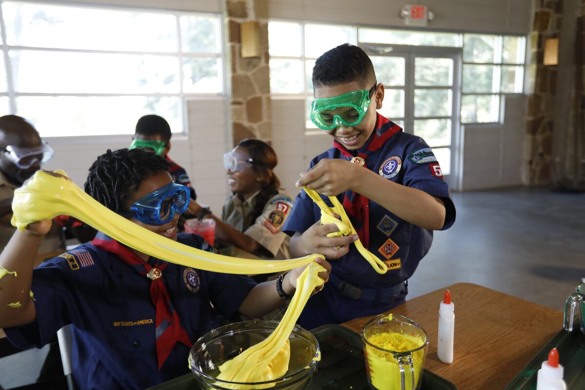 Two scouts inspecting yellow science goo